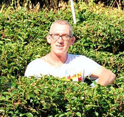 Thomas Kasper, surrounded by tea plants in Doi Mae Salong. (Photo source: Thomas Kasper)