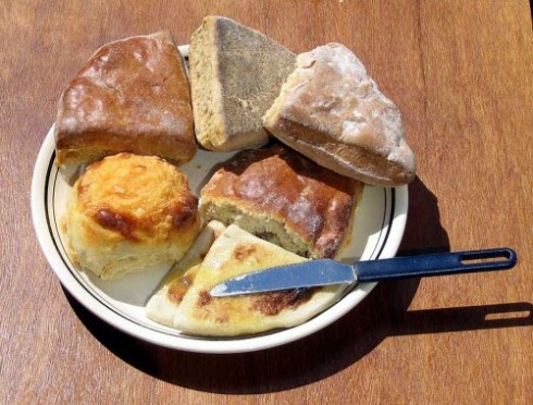 Clockwise from bottom: Hot buttered tattie scones next to a cheese scone, shiny and flat treacle scones, and a milk scone above a fruit scone. (source: Wikipedia)